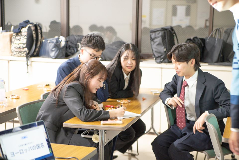 会議机を囲み、資料に書き込みながら打ち合わせを進めるメンバー