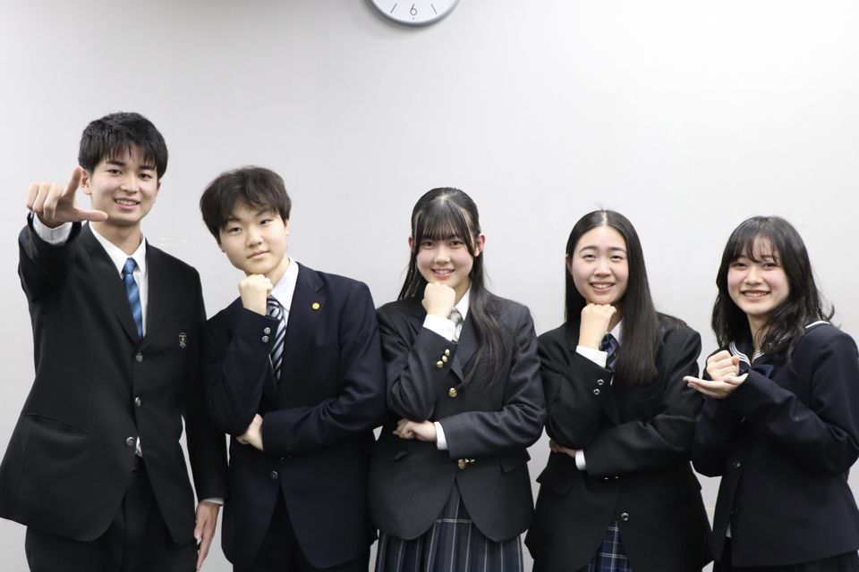制服姿の高校生5名が「考える人」のポーズで並んでいる様子