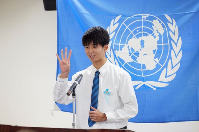 国連旗を背に、高校生の主張コンクールで演説するTEIGEN JP代表