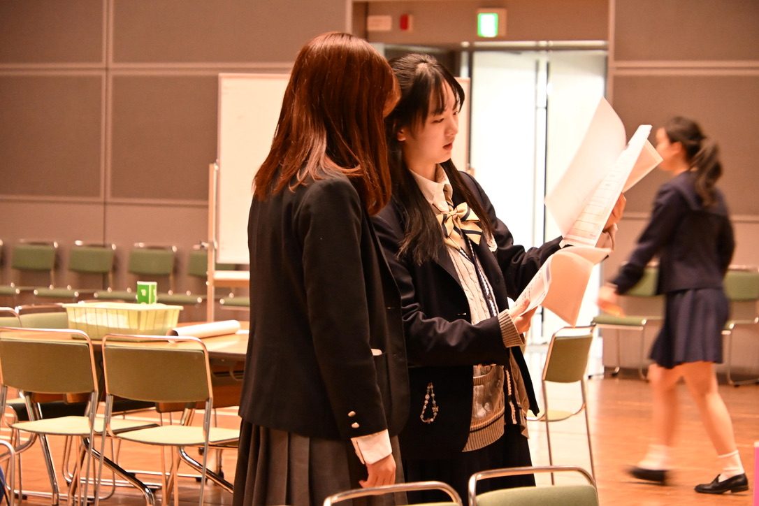 開場前の会場で、資料を手にしたメンバーが最終確認をしている様子