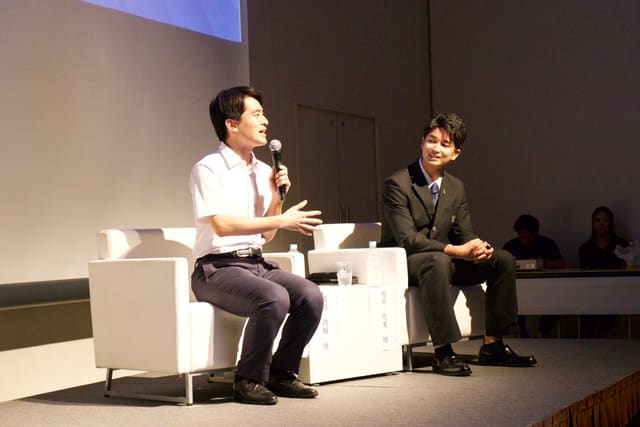 舞台上の対談セッションで、芦屋市長 高島崚輔氏の話を聞くTEIGEN JP代表